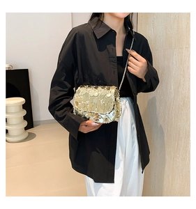 Shiny gold sequin crossbody bag with chain strap styled on a model for casual outfits