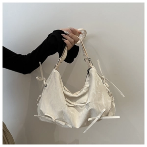 Close-up of cream white bow hobo bag featuring marble texture and ribbon accents
