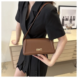Close-up of a brown leather shoulder bag with a premium gold-toned twist lock closure