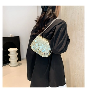 Detail shot of a shimmering silver sequin mini bag with an elegant metal chain strap