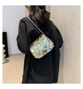 Close-up of silver sequin shoulder bag with delicate metallic chain strap on model