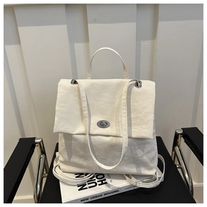 Detail of off-white pleated shoulder bag featuring a silver metal twist-lock and soft texture