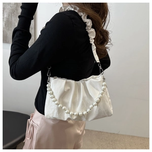 Close-up of white ruched cloud bag with elegant pearl chain and silver metal hardware