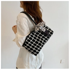 Detail of checkered tweed tote bag with elegant polka dot scarf handle decoration