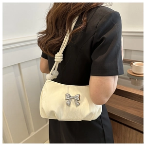 Chic cream pleated shoulder bag featuring a silver bow and beaded knot strap detail