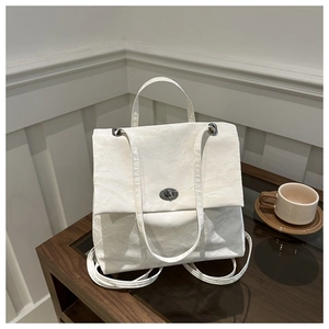 Close-up of off-white ruched fabric texture and silver twist lock on the crossbody bag