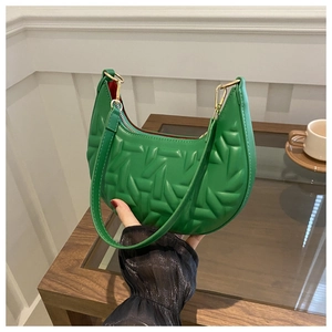 Detail view of the green quilted leather hobo bag with gold hardware and embossed texture
