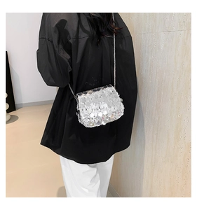 Close-up of sparkling silver sequin crossbody bag with a delicate metal chain strap