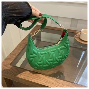 Detail of lime green hobo bag with textured geometric pattern and red lining