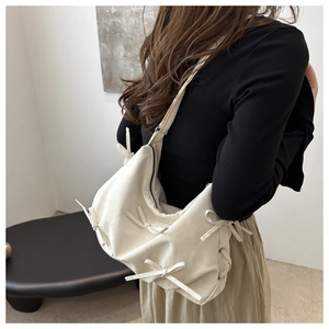 Detail of off-white tote bag with trendy bow ribbons and soft texture shoulder strap