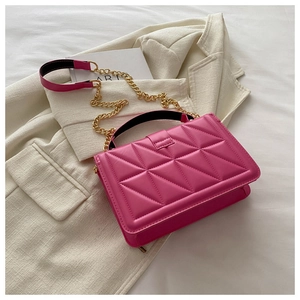 Detail of rose pink crossbody bag with triangular quilting and gold metal chain strap
