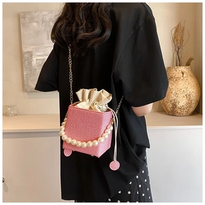 Pink woven mini cube bag with elegant pearl handle and fine gold chain strap detail