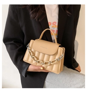 Detail of khaki pleated handbag with a thick chunky chain and elegant flip cover