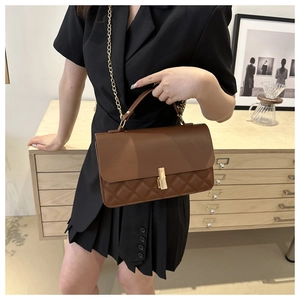 Detailansicht braune Stepptasche mit goldener Kette an einem Modell getragen
