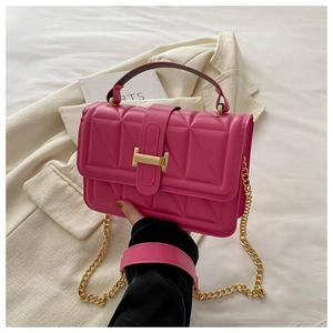 Detail of rose pink quilted crossbody bag with golden H clasp and chain strap