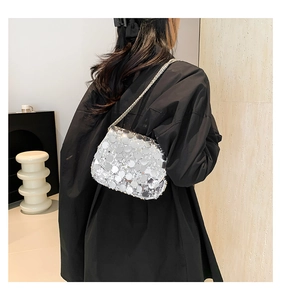Detailed view of shimmering silver sequins and fine metal chain strap on a crossbody bag