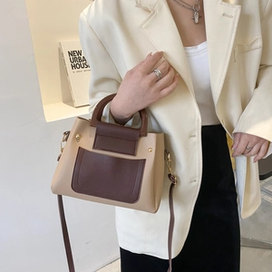 Close-up of beige and brown leather contrast stitching with elegant gold rivet details
