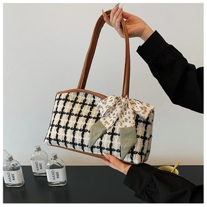 Detail of tweed tote bag featuring houndstooth pattern and floral silk scarf accessory