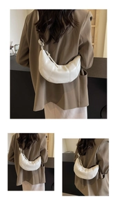 Detail of white crescent shoulder bag with knot strap design and textured PU leather