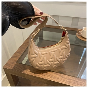 Close-up of beige hobo bag with unique 3D geometric embossing and gold hardware