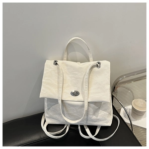 Detail of white pleated texture and silver metal twist lock on chic shoulder bag