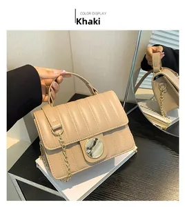 Detail of khaki quilted crossbody bag with golden chain strap and round metal buckle