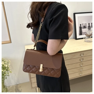 Seitenansicht einer braunen Stepptasche mit Kette am Model zur Darstellung von Größe und Stil