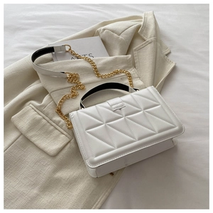 Detailed close-up of white quilted tote bag with golden chain strap and leather handle