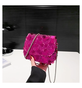 Detail of rose red sequin crossbody bag featuring a metal chain strap and luxury finish