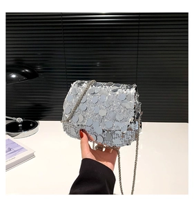 Close-up of sparkling silver sequin handbag with elegant metal chain shoulder strap