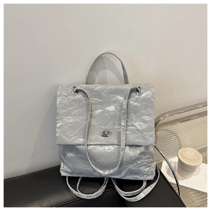 Macro detail of silver pleated texture and metallic turn-lock closure on versatile handbag