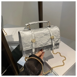 Detail of silver crinkled texture mini bag with gold round buckle and chain strap
