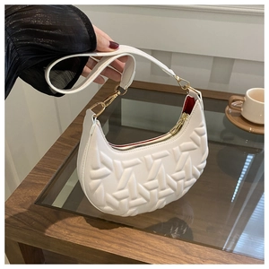 Detail of white hobo bag showing geometric textured pattern and gold hardware