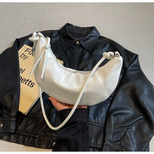Detail of white moon hobo bag showing matte leather texture and knotted shoulder strap