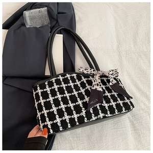 Detail of tweed tote bag with black and white texture and decorative leopard silk scarf
