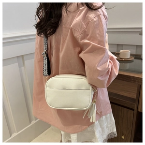 Borsa a tracolla bianca motivo litchi con ampia tracolla geometrica e nappa decorativa