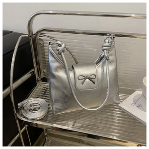 Détail du sac hobo argenté avec boucle nœud et cuir synthétique au fini froissé