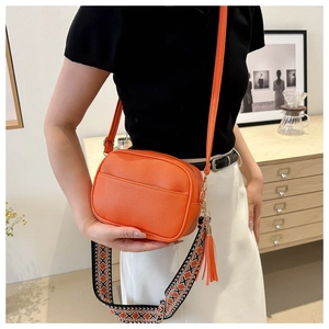Dettaglio borsa a tracolla arancione in pelle con tracolla jacquard geometrica