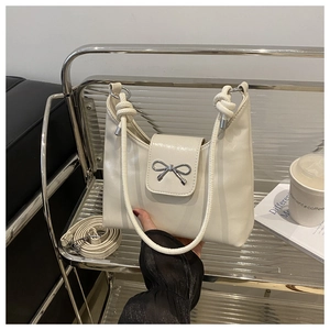 Détail du sac en cuir PU blanc crème avec nœud argenté et bandoulière amovible