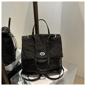 Detail of black wrinkled texture bag with silver twist lock and metallic eyelets