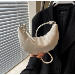 Detail of white croissant handbag with vertical stitching and matte leather texture