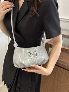 Silver pleated shoulder bag with large metallic bow and clear bead strap detail