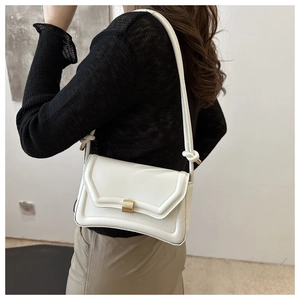 Detail of a minimalist white shoulder bag featuring quilted texture and a gold metal buckle