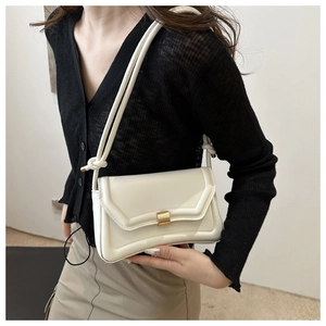 Chic cream leather saddle bag with gold metal buckle and unique knotted strap detail