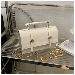 Detail of white square handbag with marble texture and golden sphere chain strap