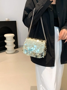 Chic silver sequined crossbody bag with silver chain strap shown on a model