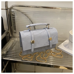 Close-up of light blue bag featuring ice-crack texture and golden metal buckle details