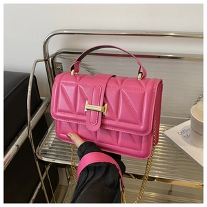 Detail of rose pink quilted crossbody bag with golden clasp and chain shoulder strap