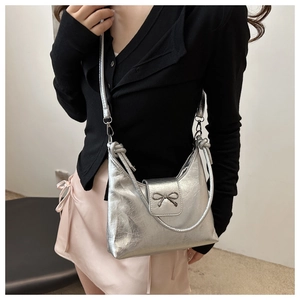 Détail du sac argenté métallisé montrant le cuir synthétique et la poignée tressée