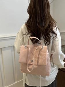 Pale pink soft pleated shoulder bag with silver clasp shown on a model for scale